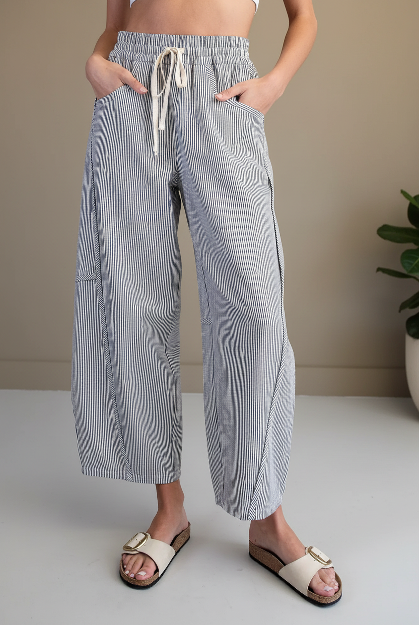 Striped drawstring barrel pants front waist-down detail — deep side pockets, cream drawstring tie, navy pinstripe cotton fabric