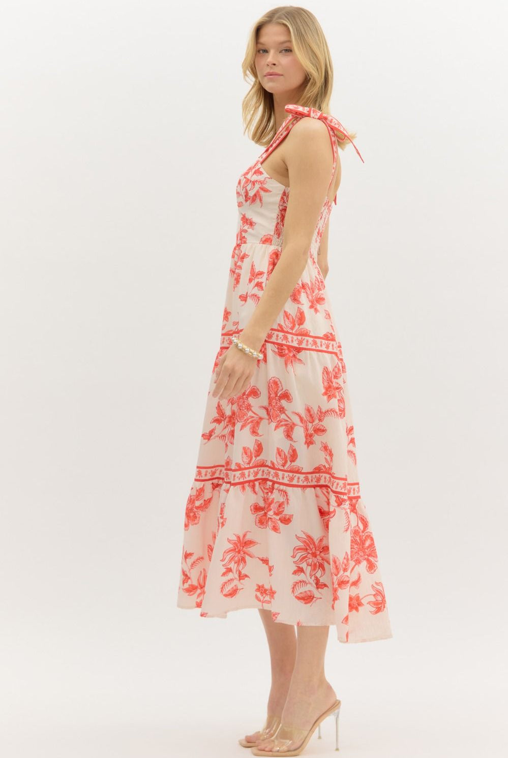 Model wearing a cream and burnt orange floral tiered maxi dress with tie straps, lined with hidden side pockets – Sunset Soirée Maxi