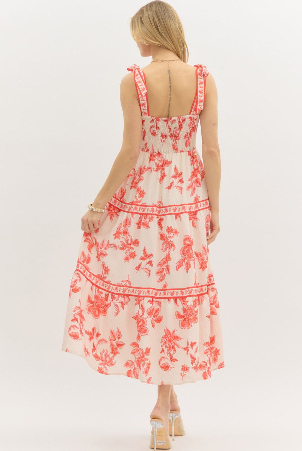 Model wearing a cream and burnt orange floral tiered maxi dress with tie straps, lined with hidden side pockets – Sunset Soirée Maxi