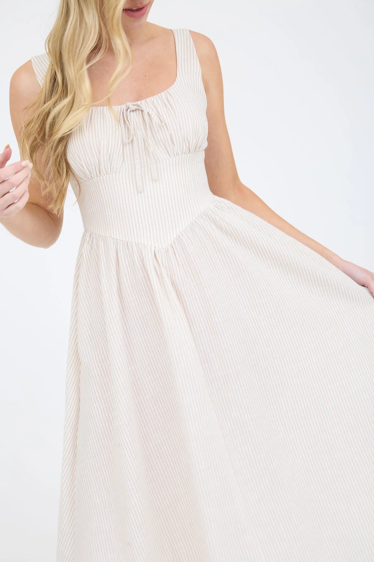 A coastal chic fashion staple, this sleeveless striped dress is made from a lightweight, breathable fabric. The image captures the crisp texture of the taupe stripes and the structured yet airy drape of the A-line summer dress silhouette taupe and white