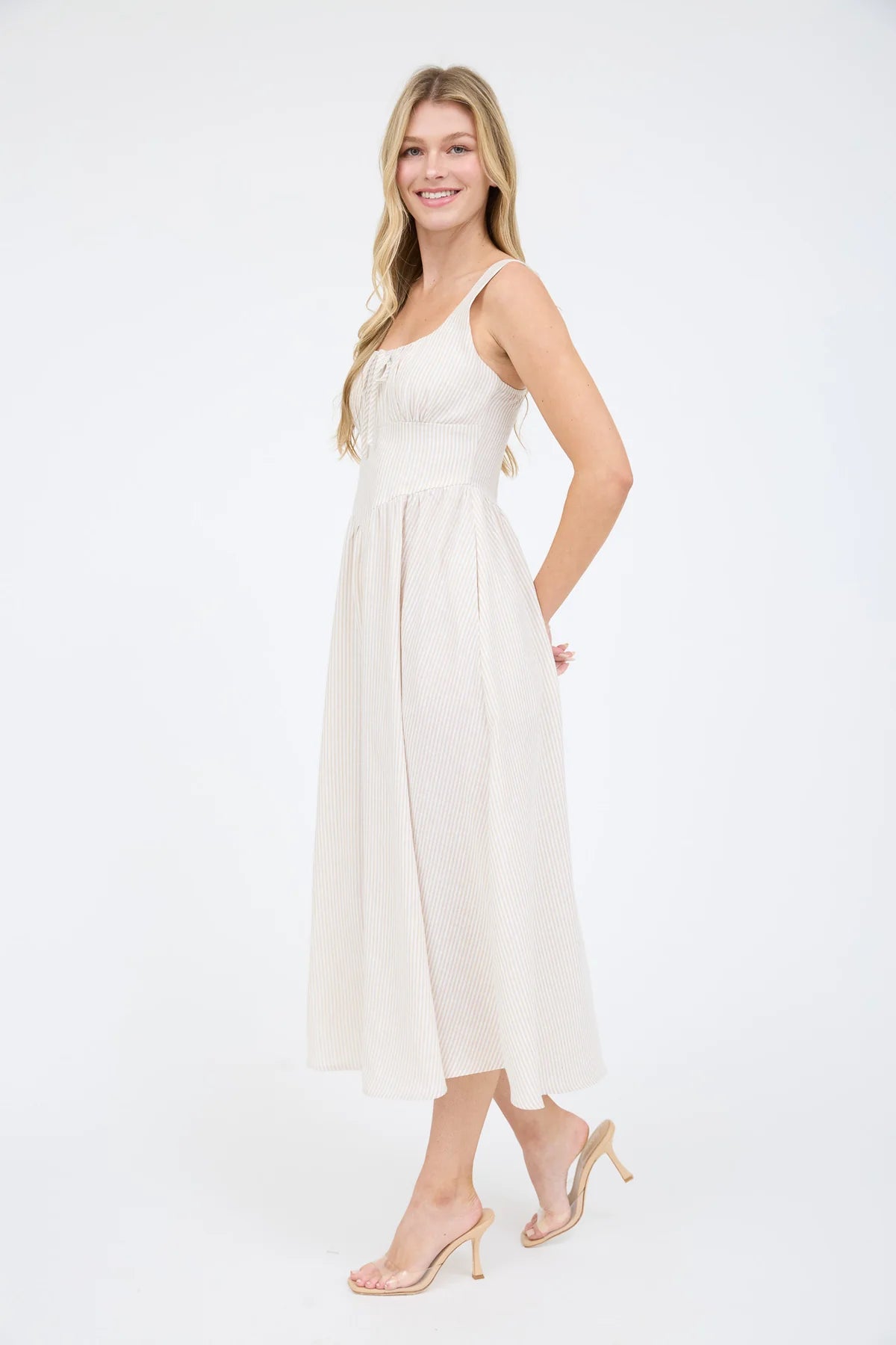 A coastal chic fashion staple, this sleeveless striped dress is made from a lightweight, breathable fabric. The image captures the crisp texture of the taupe stripes and the structured yet airy drape of the A-line summer dress silhouette lined and zipper back