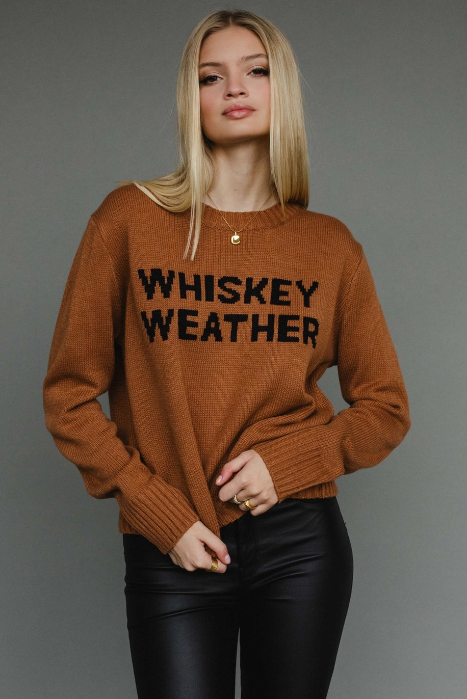 Camel knit sweater with “Whiskey Weather” black lettering, relaxed cozy fit.