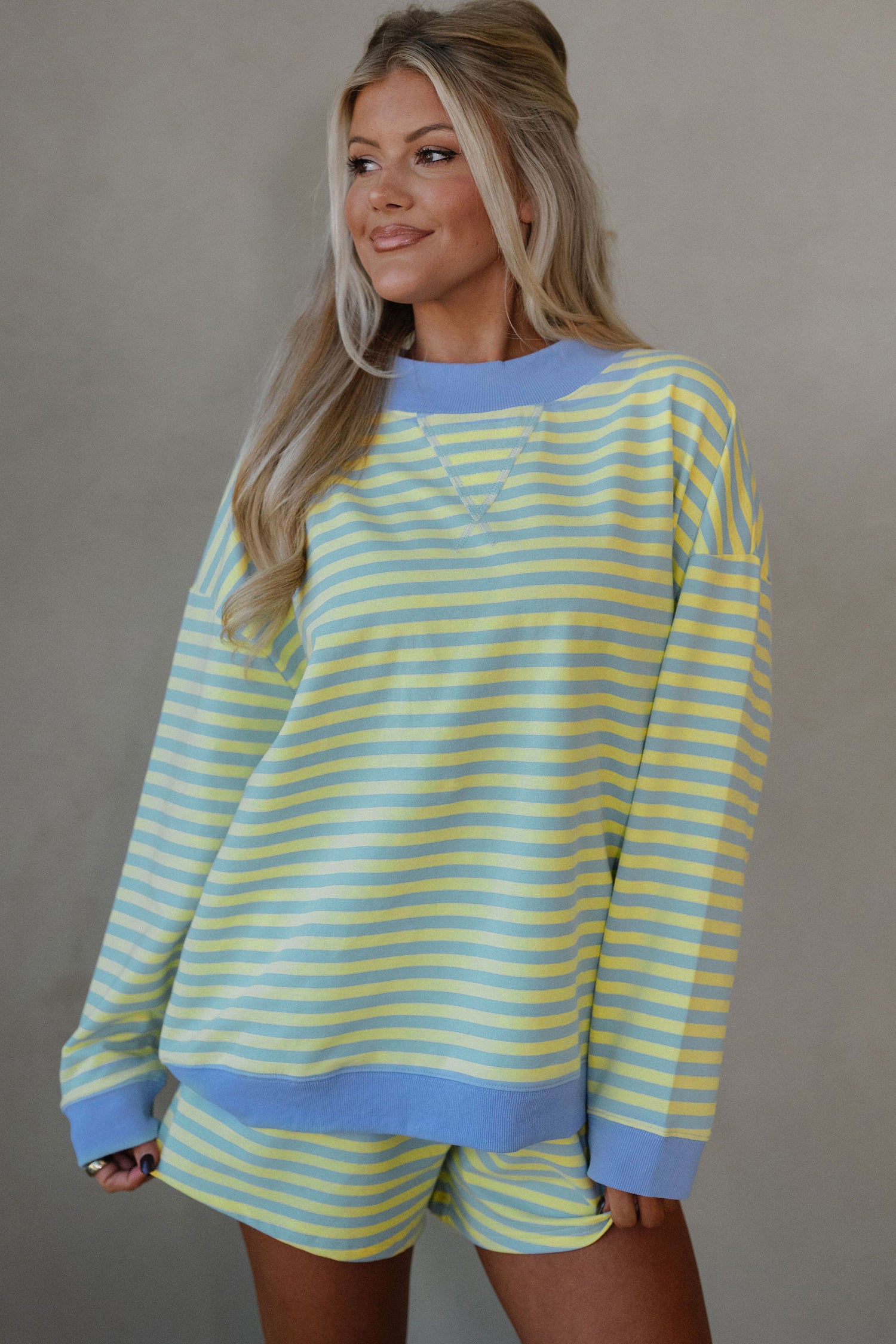 yellow and blue striped mock neck pullover and shorts matching set for women, trendy stripe two piece lounge outfit with color block trim, women’s striped matching set featuring mock neck top and loose fit shorts, casual boutique striped outfit set