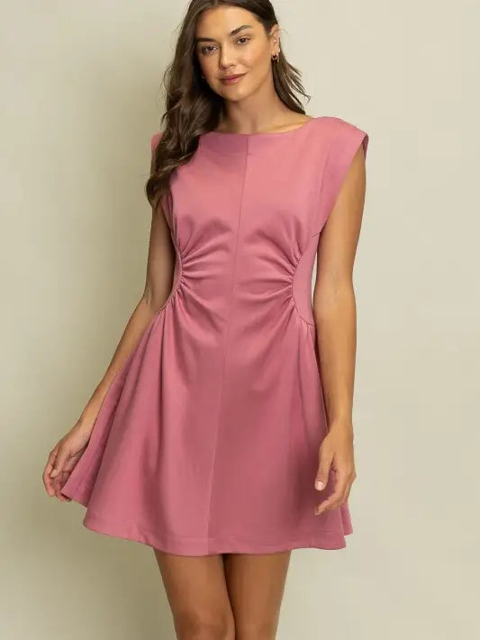pink sleeveless mini dress with side cutouts, ruched waist detail, and flared skirt