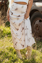 woman wearing a satin cream skirt with western print lined