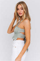 A stylish smocked tank top featuring a square neckline and criss-cross back tie, offering a flattering fit and a trendy, feminine touch. Perfect for casual chic outfits and summer styling.