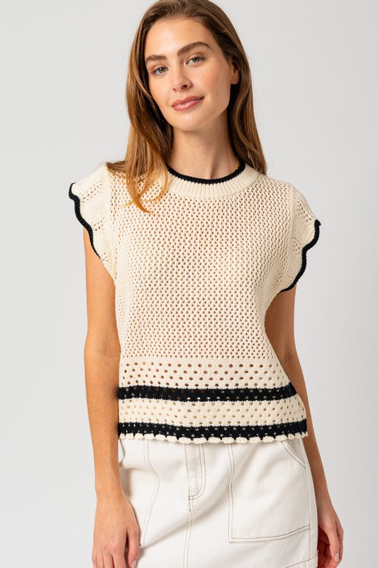 Model wearing a sleeveless round neck crop top with ruffle sleeves and color contrast trim, styled with high-waisted jeans — perfect for casual summer outings or brunch dates.