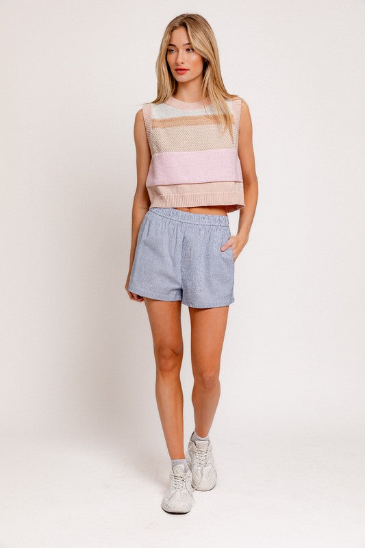 A fashionable round neck sweater vest with a sleeveless design, perfect for layering over blouses or wearing solo for a sleek, modern look. Ideal for creating preppy, casual, or chic outfits year-round.