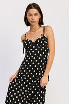 Flowy maxi dress with classic polka dot print and fitted bodice. Thread Bar Boutique