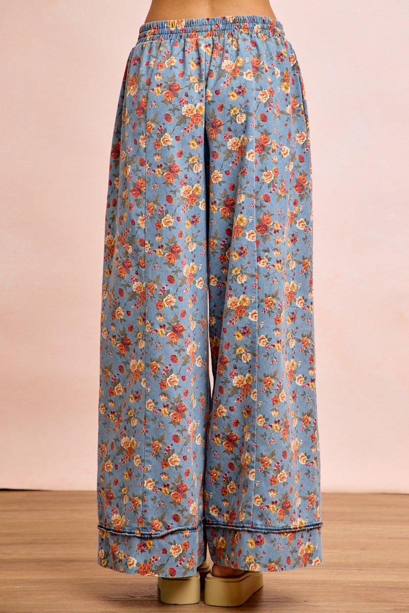 Back view of dusty blue wide leg pants with colorful floral print and drawstring detail