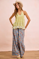 Bloom & Flow wide leg pants in dusty blue with vibrant floral print, featuring drawstring waist and side pockets
