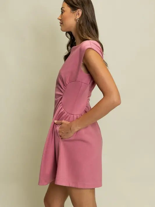 Mauve pink sleeveless mini dress with side cutouts, ruched waist detail, and flared skirt side view
