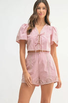 Two-piece outfit featuring a crochet lace crop top and matching high-waisted shorts, styled for a soft and feminine summer look.


