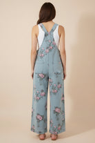 Vintage-inspired floral denim overalls at Thread Bar Boutique with pleated waist and feminine pink and sage print.