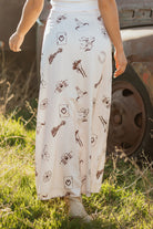 woman wearing a cream satin westen inspired print skirt