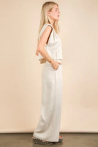  woman wearing a beige woven two-piece set with wide-leg pants and a sleeveless cropped top, styled for a chic minimalist look