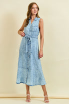 Sleeveless light wash denim midi dress with button front, tie waist belt, and ruffle hem