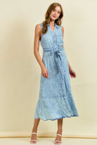 Sleeveless light wash denim midi dress with button front, tie waist belt, and ruffle hem