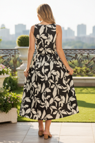Women's coordinated black and cream leaf print outfit with a cropped tank top, pleated midi skirt, elastic waistband, and side pockets.