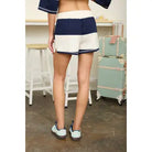 Relaxed rugby stripe knit set featuring a dropped-shoulder half-zip pullover and matching shorts. Comfortable women's boutique outfit perfect for weekend wear, lounging, and travel style inspiration.