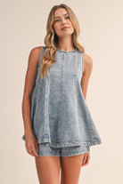 Back view of a women's denim two piece outfit showing the keyhole button closure, fit and flare silhouette, and matching high-rise shorts.