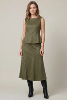 Women's structured suede-feel peplum top styled for a night out with a sophisticated fitted silhouette and boat neckline