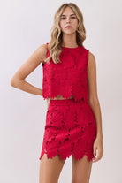 Sleeveless floral lace crop top with intricate cutout detailing, round neckline, relaxed boxy fit, and scalloped floral hem