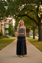 Black lace trim two-piece skirt set featuring a fitted crop top with smocked back, flowing maxi skirt, invisible back zipper, and delicate lace detailing. Lightweight lined matching set for game day outfits, football season, brunch, concerts, vacations, and special events.