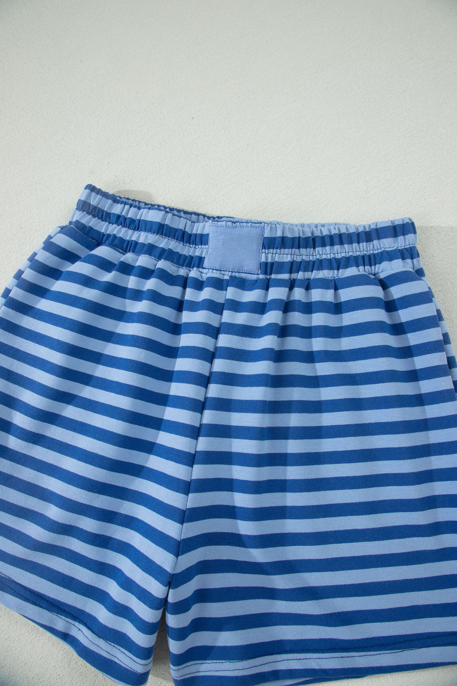 Blue striped shorts on a light gray background