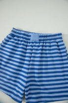 Blue striped shorts on a light gray background