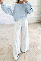 Women’s light blue lounge set featuring a cropped sweatshirt and matching wide-leg drawstring pants, combining a relaxed silhouette with a playful colorblock polka dot design.