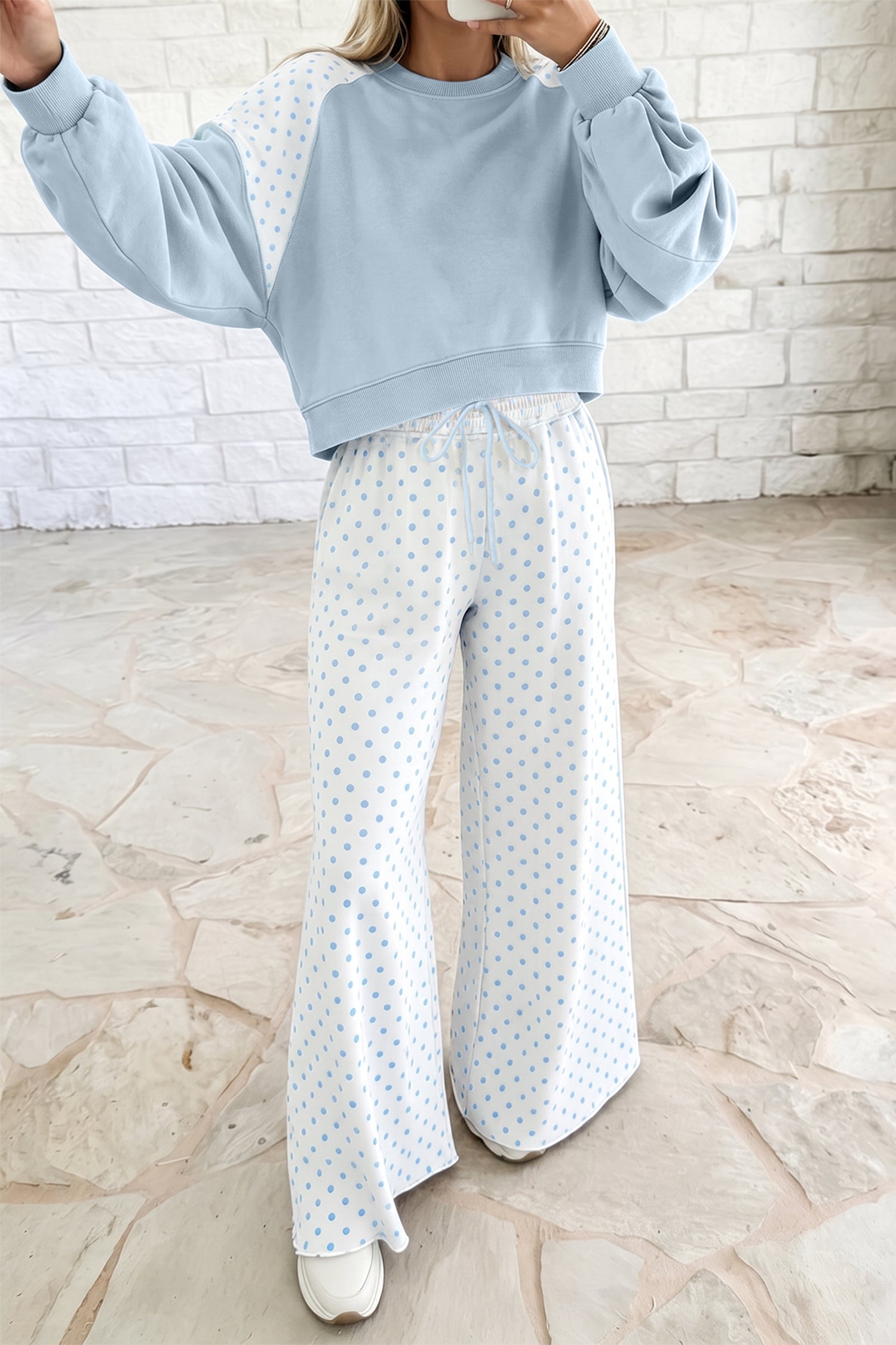 Women’s light blue lounge set featuring a cropped sweatshirt and matching wide-leg drawstring pants, combining a relaxed silhouette with a playful colorblock polka dot design.