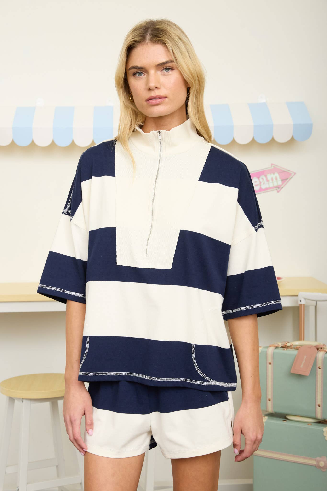 Women's knit short set with bold contrast rugby stripes, oversized silhouette, and matching high-rise shorts. Trendy athleisure-inspired boutique outfit for everyday comfort and style.