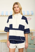 Women's knit short set with bold contrast rugby stripes, oversized silhouette, and matching high-rise shorts. Trendy athleisure-inspired boutique outfit for everyday comfort and style.
