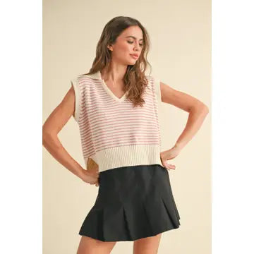 A model wearing a pink striped sleeveless knit vest with a V-neckline and ribbed hem