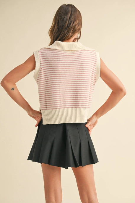 A model wearing a pink striped sleeveless knit vest with a V-neckline and ribbed hem