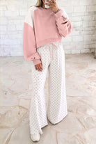 Pink women’s matching set with a cropped crew neck sweatshirt, long balloon sleeves, ribbed cuffs, and coordinating wide-leg pants with an elastic drawstring waist