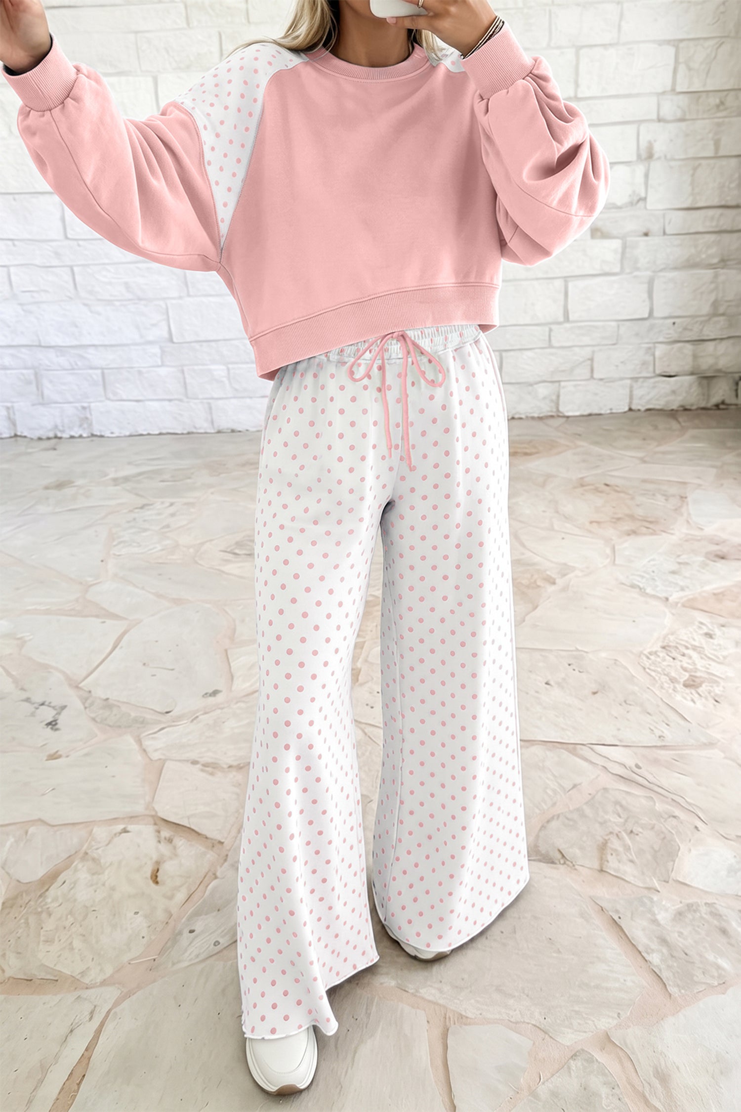 Women’s pink lounge set with a cropped sweatshirt and matching wide-leg drawstring pants, featuring a playful colorblock polka dot print and comfortable relaxed fit.