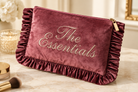 Close-up of The Essentials mauve velvet ruffle makeup bag texture and embroidery great for gifting