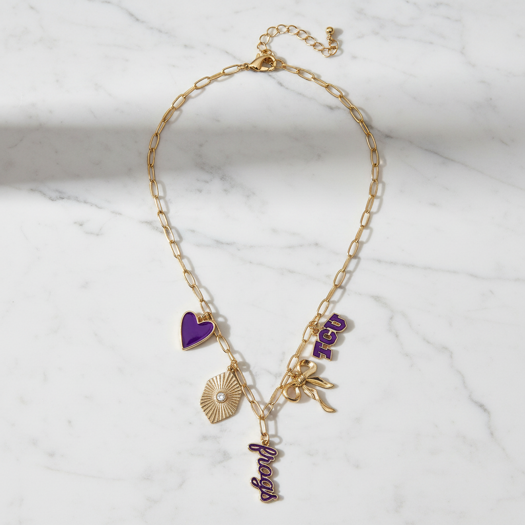TCU Horned Frogs charm necklace with gold paperclip chain, featuring purple heart, TCU logo, bow, and “Frogs” script charms in 18K triple plated gold