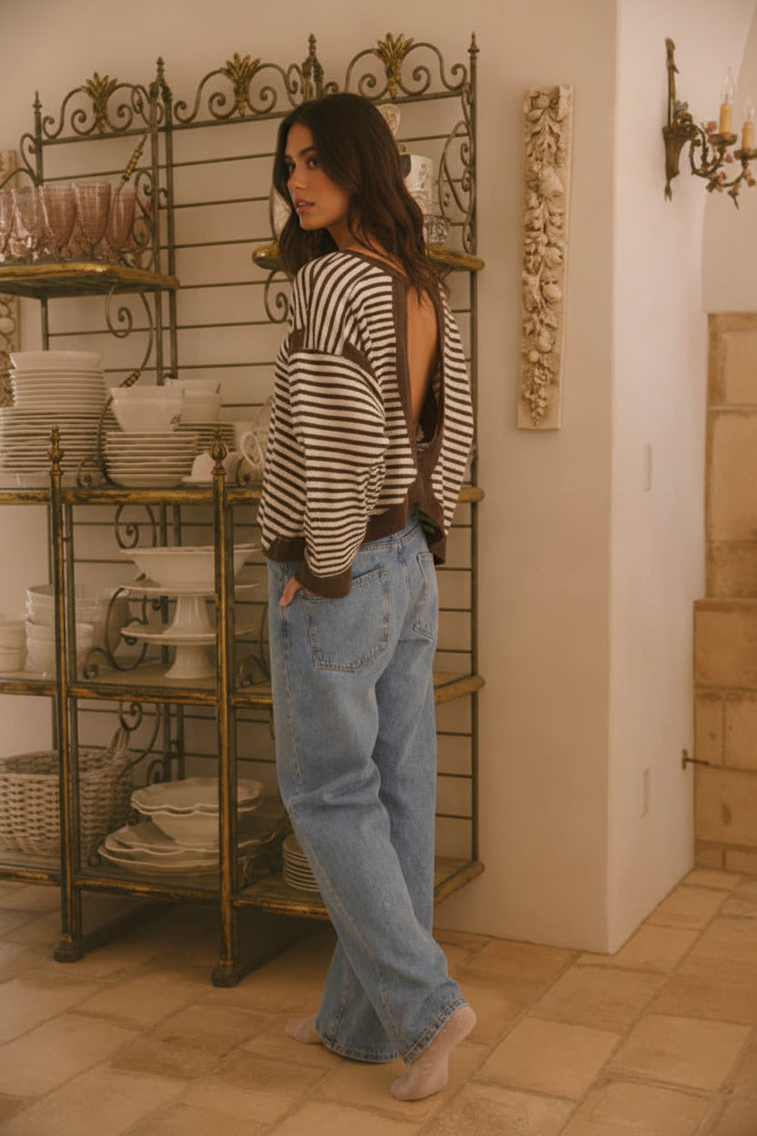Angled back view of a striped knit top showcasing the keyhole cutout, tulip hem design, and relaxed fit silhouette from Thread Bar Boutique.