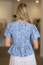 Women's embroidered tie front blouse from Thread Bar Boutique with delicate floral embroidery, short sleeves, scalloped details, and a flattering peplum silhouette. Chic boutique top for casual outings and elevated everyday outfits.