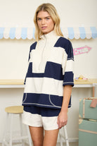 Matching rugby stripe knit outfit featuring an oversized zip-neck top and coordinating shorts. Stylish boutique set for vacation travel, resort wear, airport outfits, and casual summer fashion.