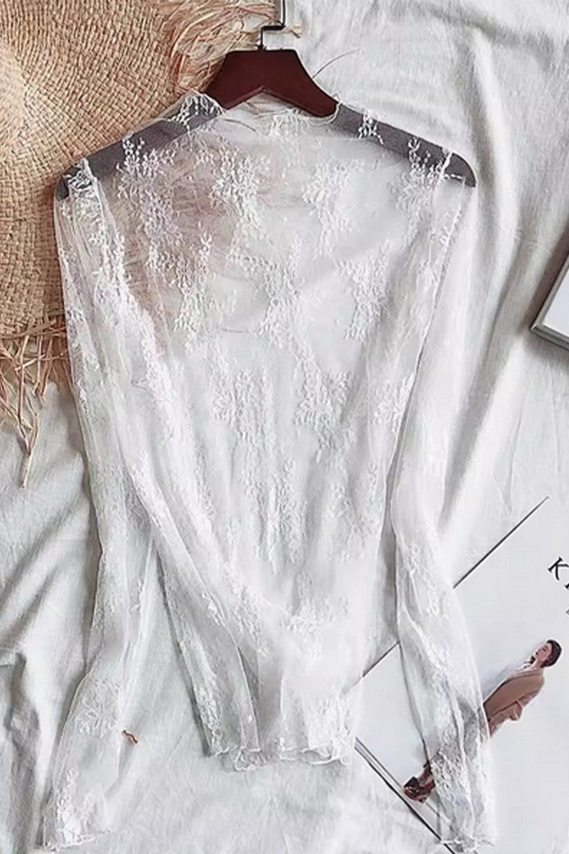 White lace dress on a hanger with a neutral background