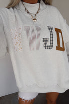 Women's WWJD embroidered patch sweatshirt with mixed floral, plaid, and striped fabric appliqué details, mock neck, long sleeves, and relaxed fit — a cozy Christian faith sweatshirt for everyday wear.
