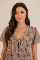 Soft washed cotton blend utility romper with short sleeves, cuffed shorts, and deep V neck tie detail from Thread Bar Boutique