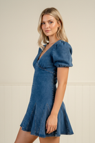 Effortless denim mini dress with feminine puff sleeves and godet hem detailing, offering a flirty flared silhouette for brunch, game days, date nights, and casual weekend outfits.