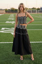 Fashion-forward black coordinated two-piece set featuring a fitted lace trim top and elegant flowy maxi skirt with invisible zipper closure. Lightweight lined boutique outfit ideal for game day fashion, brunch dates, country concerts, vacations, and seasonal events.