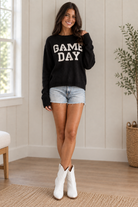 Women’s black and white Game Day knit sweater for football season, featuring bold white lettering and a relaxed fit that pairs with team-color skirts, jeans, boots, and tailgate accessories from Thread Bar Boutique