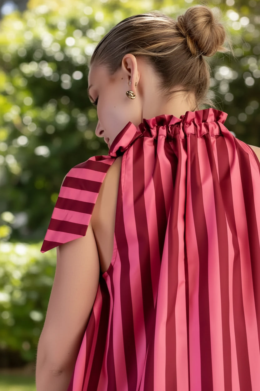 Close-up of a women's striped top showing the ruffled tie neckline and self-tie bow detail, creating a feminine and polished look for summer outfits.